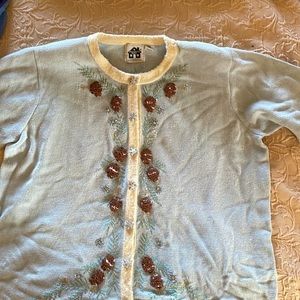3x Storybook Knits cardigan with snowflake buttons and pine cone decor.
